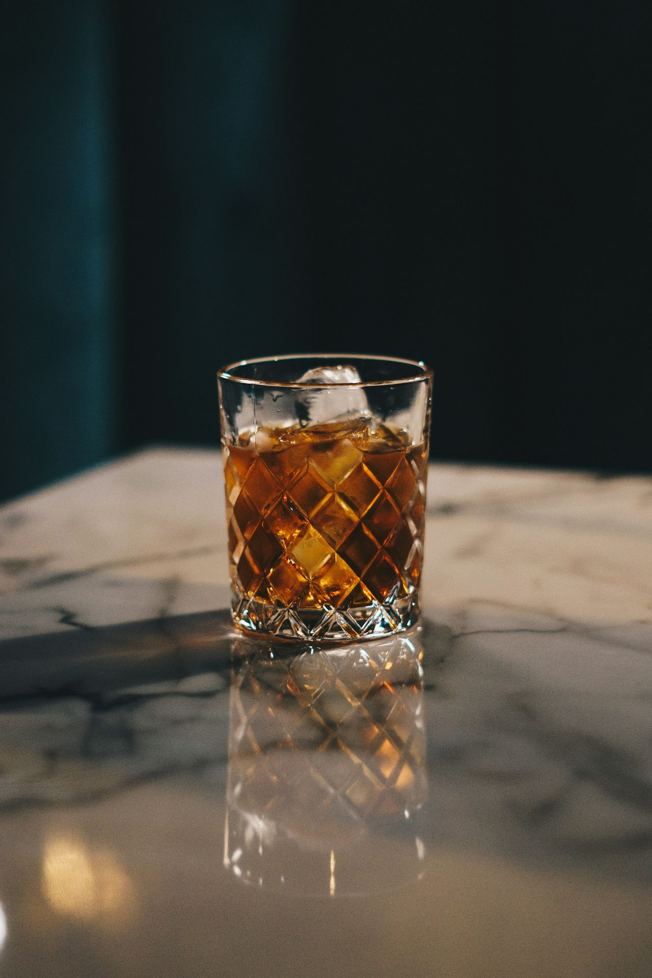 a glass of whiskey sitting on top of a table